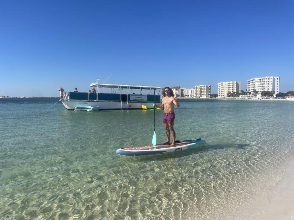 stand up paddle board in front of bikkini bottom boat charter tour in destin florida
